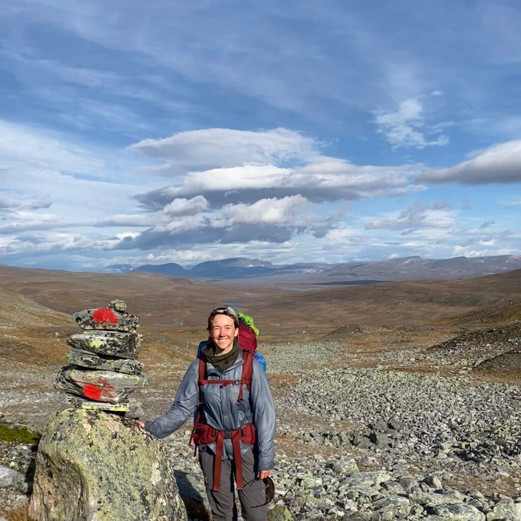 Kvinna på vandring ler mot kameran