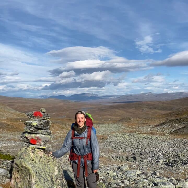 Kvinna på vandring ler mot kameran